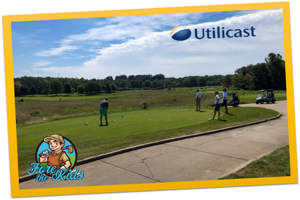 Players on the tee at the Fore the Kids golf outing, under a Utilicast banner